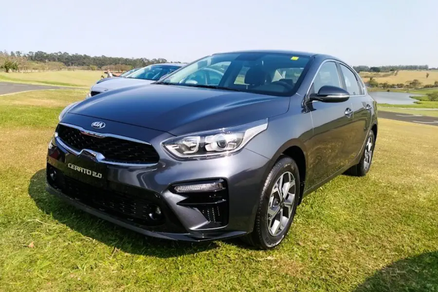 Kia Cerato 2020 vermelho em uma cidade à noite, destacando seu design moderno.