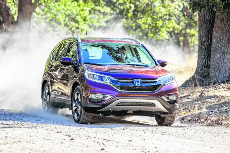 Honda CR-V 2015 cinza estacionado em frente a uma casa, ideal para famílias.