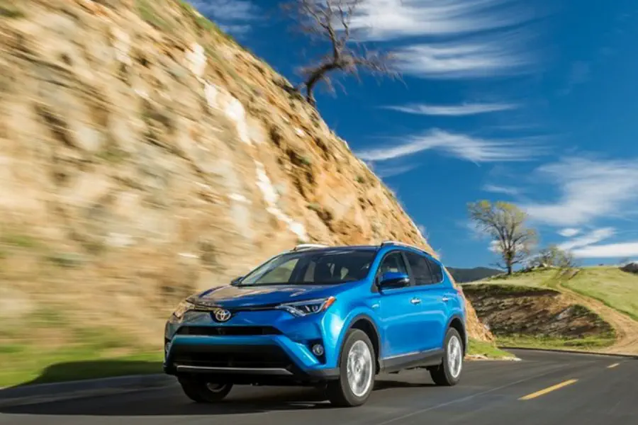 Toyota RAV4 2016 prata em uma estrada de terra, demonstrando sua robustez.